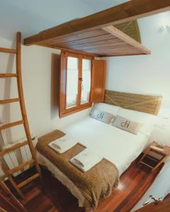 a bedroom with a white bed with a ladder at El Piolet de Camprodon in Camprodon