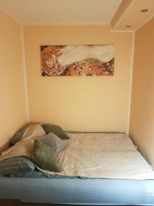 un letto in una stanza con un dipinto sul muro di Apartament W2, Mieszkanie dla Wszystkich a Konin