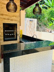uma cozinha com uma bancada e uma lareira em Chalé Suíço em Guaramiranga