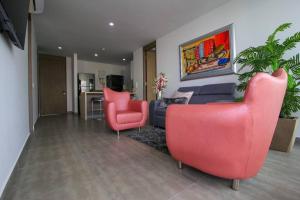 sala de estar con 2 sillas rojas y sofá en Cerca al Hotel Americas Ctgna Spiaggia Morros Piscina playa, en Cartagena de Indias