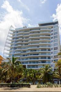 un gran edificio con palmeras delante en Cerca al Hotel Americas Ctgna Spiaggia Morros Piscina playa, en Cartagena de Indias