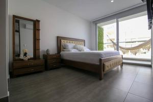 a bedroom with a bed and a dresser and a mirror at Cerca al Hotel Americas Ctgna Spiaggia Morros Piscina playa in Cartagena de Indias