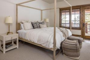 a bedroom with a canopy bed and a chair at Western Tanager Cabin in Big Sky