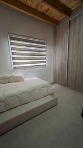 a bedroom with a large bed and a window at Casa Yaqui in Guaymallen