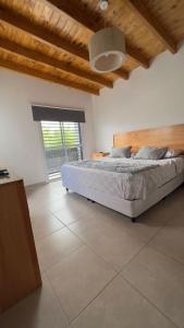 a bedroom with a bed and a large window at Casa Yaqui in Guaymallen