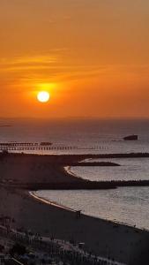 una puesta de sol en una playa con la puesta de sol sobre el océano en Hotel Ocean View Residence, en Fortaleza