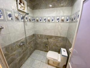 a bathroom with a shower and a toilet and a sink at Almazham holiday house in Al-ʿUla