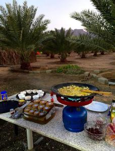 a table with a bunch of food on it at Almazham holiday house in AlUla