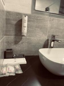 W łazience znajduje się umywalka, lustro i umywalka. w obiekcie Hotel Callisto w Prisztinie