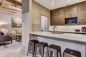 a kitchen with a sink and two stools at Parker's Collection Unit 3 in Savannah