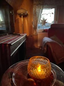 a candle on a glass table in a room at An der Heide. in Braunsteich