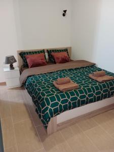 - une chambre dotée d'un lit avec des oreillers verts et rouges dans l'établissement Apartman KLM, à Pančevo