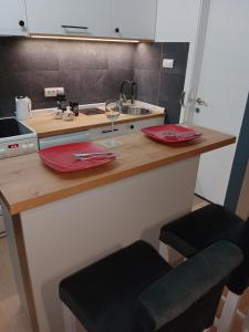 une cuisine avec un évier et un comptoir avec deux verres dans l'établissement Apartman KLM, à Pančevo