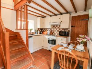a kitchen with a wooden table and chairs and a staircase at Walkmill Barn in Bishops Castle