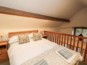 a bedroom with a bed and a wooden railing at Walkmill Barn in Bishops Castle