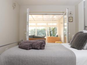 een slaapkamer met een bed en een groot raam bij Fern Cottage in Redruth