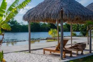 - une plage avec 2 chaises et un parasol dans l'établissement Pousada Marina, à Barreirinhas