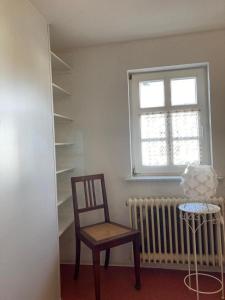 een kamer met een stoel, een raam en een radiator bij Ferienwohnung Lukas in Frielendorf