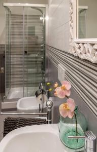 a bathroom with a sink with a vase with flowers in it at Luxury Apartment Manarola by Arbaspàa in Manarola
