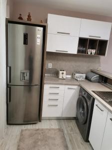 eine Küche mit einem Kühlschrank aus Edelstahl und weißen Schränken in der Unterkunft Markoni in Sliven