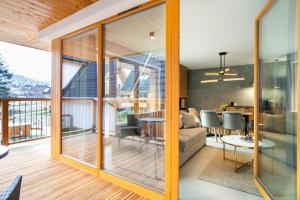 uma sala de estar e sala de jantar com portas de vidro deslizantes em Apartament Tarasowa Polana by Apart Concept Podhale em Kościelisko