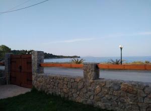 a stone wall with a gate and a fence at Villa Agali. in Agia Anna