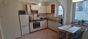 Una cocina con electrodomésticos blancos y una mesa con sillas. en Apartament Żabi Kruk, en Gdansk