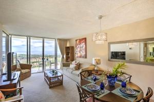 a living room with a table and a couch at Makaha Condo Near Pokai Bay Beach with Ocean View! in Waianae