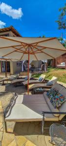 a group of lounge chairs and an umbrella at Pousada Papyrus in Tiradentes