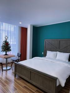 a bedroom with a large bed and a christmas tree at Cuti House in Da Lat