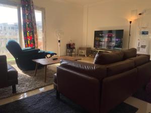 sala de estar con sofá y TV en Relax Inn, en New cairo