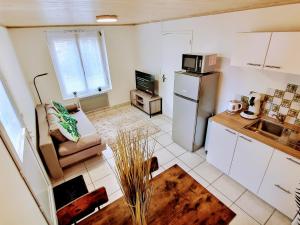 a small kitchen with a couch and a refrigerator at Into the Wild - T2 Cosy tout confort in Bouguenais