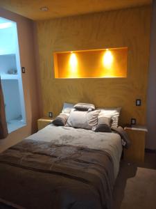 - une chambre avec un lit et deux lumières sur le mur dans l'établissement PentHouse con Roof Garden Privado Aeropuerto CDMX, à Mexico