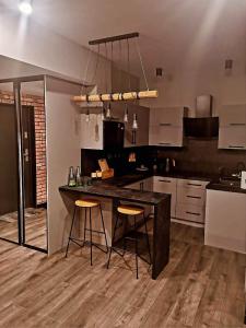 een keuken met een tafel en 2 barkrukken bij Apartament W Starym Obiektywie in Kowary