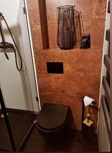 a bathroom with a toilet with a basket on the wall at Apartament W Starym Obiektywie in Kowary