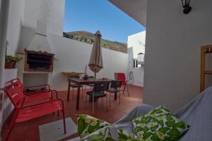 a living room with a table and chairs and an umbrella at Casa MarySol Tamaduste 12m from the Sea, Terrace & BBQ in Tamaduste
