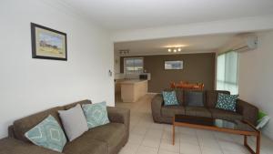 a living room with two couches and a table at Sunnyvale unit 1 in Yamba