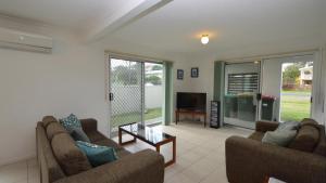a living room with two couches and a tv at Sunnyvale unit 1 in Yamba