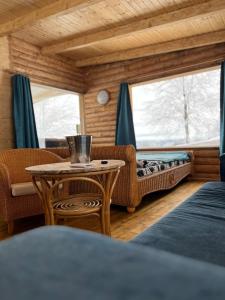 Habitación con mesa, sofá y ventana en Cabana Himalaya Lodge cu ciubăr din inima munților Apuseni- masivul Buces -Vulcan, 