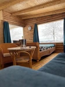 una stanza con un tavolo, un divano e una finestra di Cabana Himalaya Lodge cu ciubăr din inima munților Apuseni- masivul Buces -Vulcan a Buceş-Vulcan