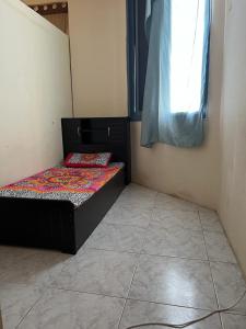 a small room with a bed with a window at Stay at gomeetingwith in Sharjah