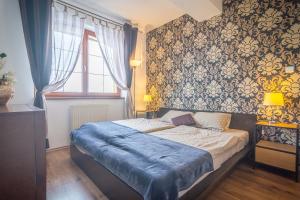 a bedroom with a bed with a blue blanket on it at TATRYSTAY Great Apartment - 2 King size beds in Veľká Lomnica