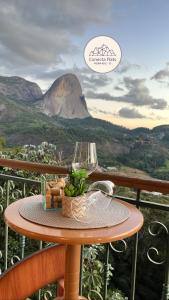 a table on a balcony with a view of a mountain at Conecta Flats - De frente para Pedra Azul in Pedra Azul