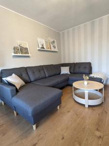 ein Wohnzimmer mit einem blauen Sofa und einem Tisch in der Unterkunft Bis zu 6 Personen, Bahnhofs- & Zentrumsnah, Südheide, Netflix und PS4 in Celle