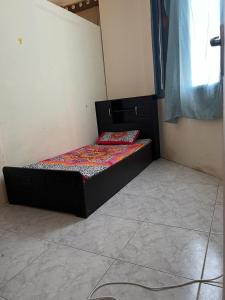 a small bed sitting in a corner of a room at Stay at gomeetingwith in Sharjah