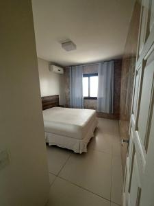a small bedroom with a bed and a window at Apartamento Beira Mar Arroio do Silva - 2 quartos - nº42 in Arroio do Silva