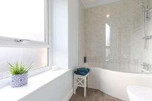 a white bathroom with a tub and a sink at Folly View - Private, peaceful apartment with stunning views. in Pateley Bridge