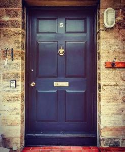 a blue front door of a brick building at Folly View - Private, peaceful apartment with stunning views. in Pateley Bridge