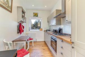 uma cozinha com armários brancos e uma mesa e uma mesa sidx sidx sidx em Folly View - Private, peaceful apartment with stunning views. em Pateley Bridge