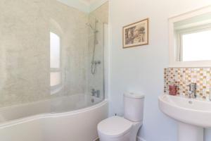 a white bathroom with a toilet and a sink at Folly View - Private, peaceful apartment with stunning views. in Pateley Bridge